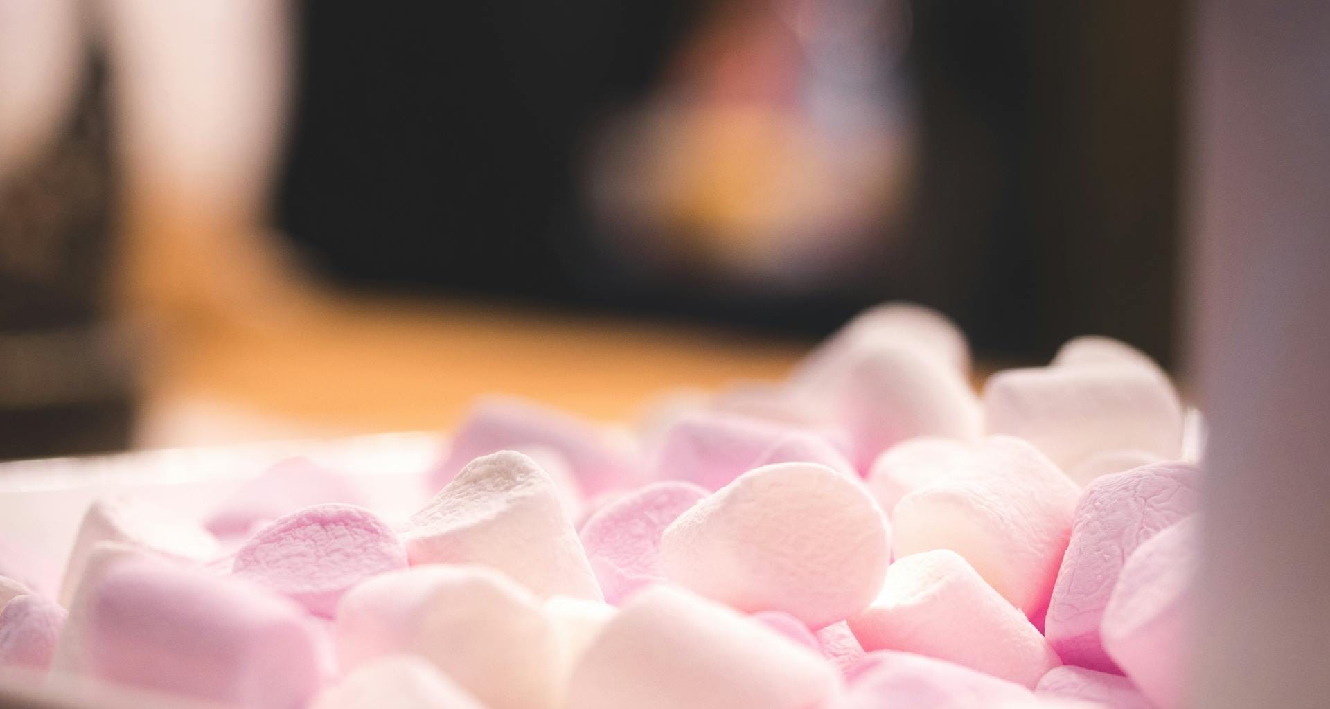 Delightful close-up of pink and white marshmallows in warm lighting, perfect for sweet treat themes.