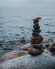 A serene stack of stones on the rocky beach by the ocean, symbolizing balance.